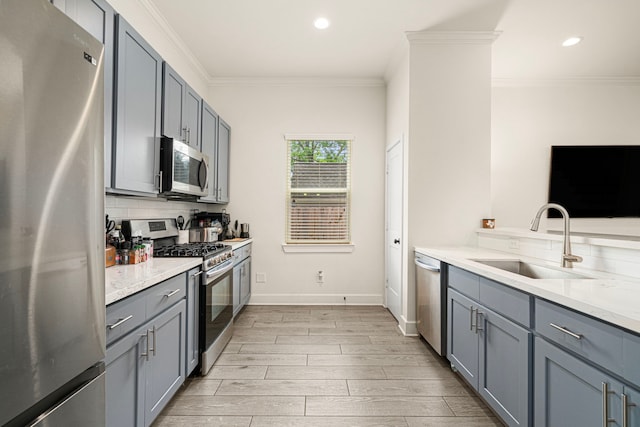 kitchen featuring stainless steel appliances, a sink, light wood-style floors, decorative backsplash, and gray cabinets