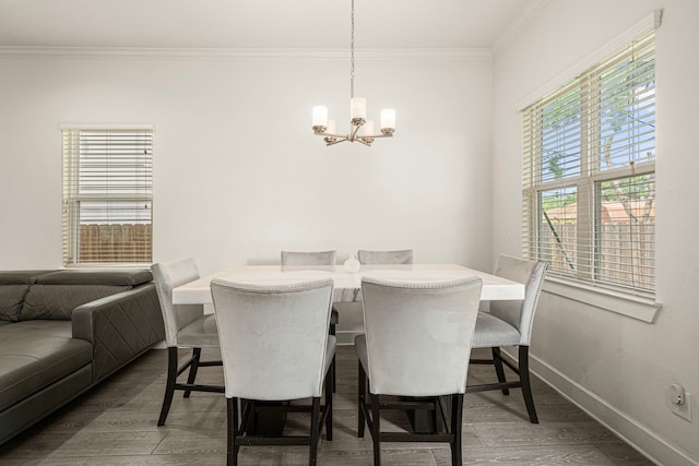 dining room featuring wood finished floors, baseboards, ornamental molding, and an inviting chandelier