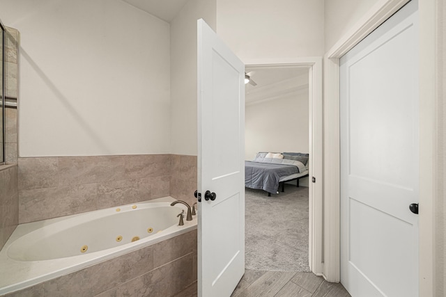 full bathroom featuring wood finished floors, a jetted tub, and connected bathroom