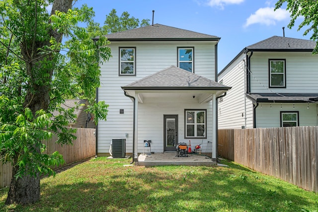 rear view of property with a fenced backyard, central AC unit, a yard, and a patio