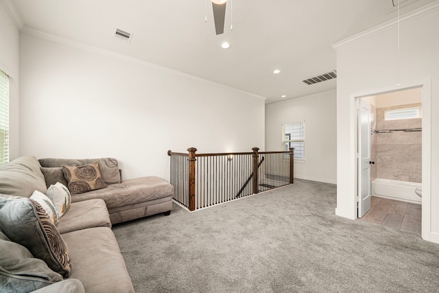 carpeted living room featuring attic access, crown molding, and visible vents