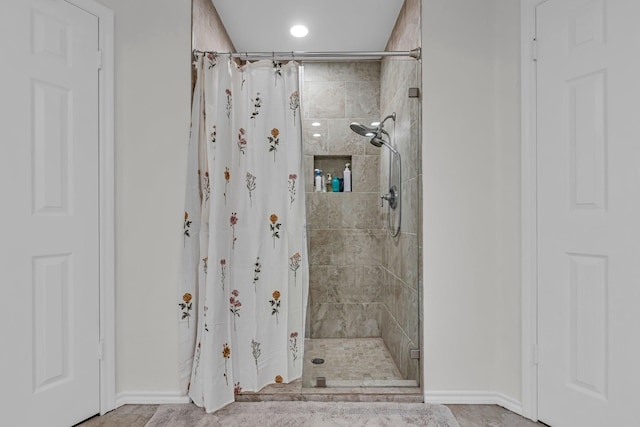 bathroom with baseboards, a shower stall, and recessed lighting