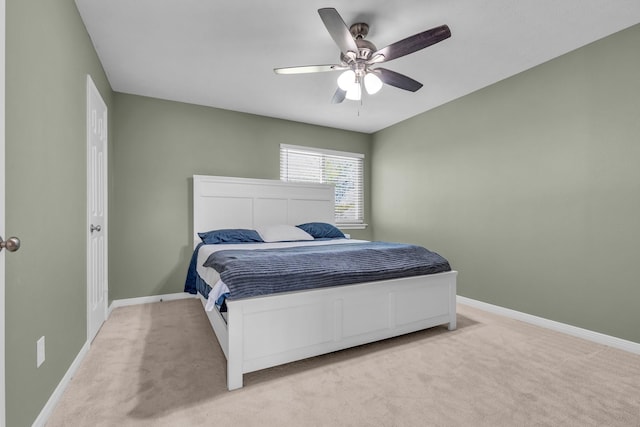 bedroom featuring a ceiling fan, baseboards, and light colored carpet