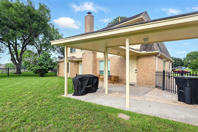 back of property with a yard, brick siding, fence, and a patio area