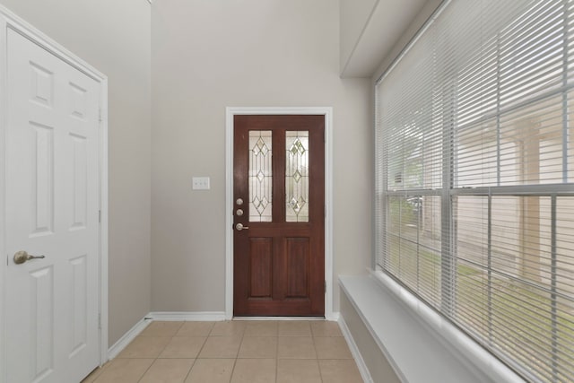 entryway with baseboards and light tile patterned floors