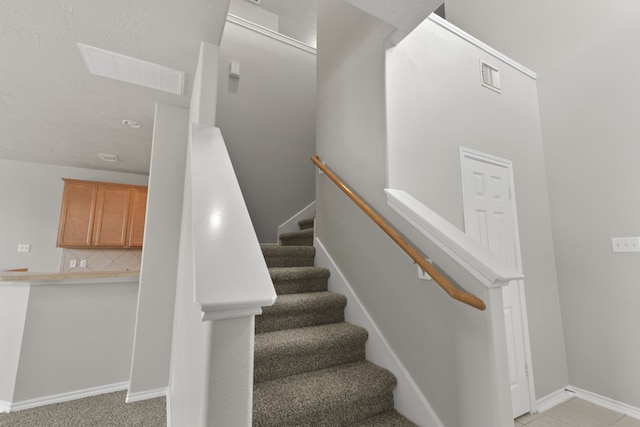 stairway with visible vents and baseboards