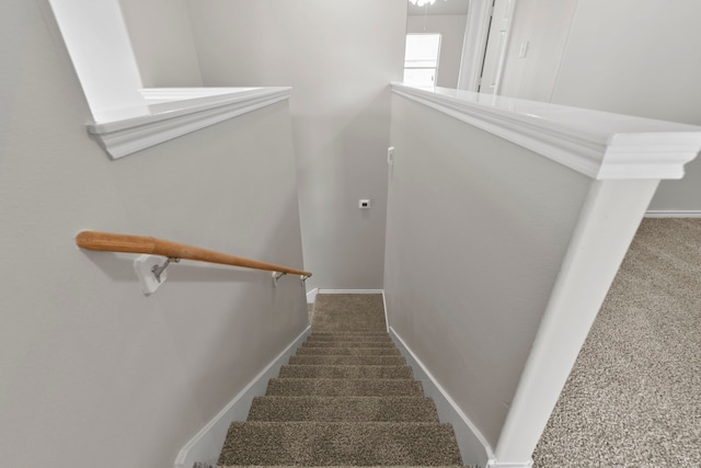 staircase featuring carpet floors and baseboards