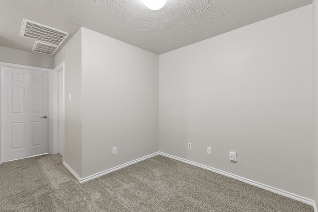 carpeted spare room featuring baseboards and visible vents