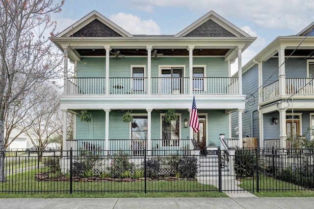 view of front of house featuring a fenced front yard, a porch, a balcony, and ceiling fan