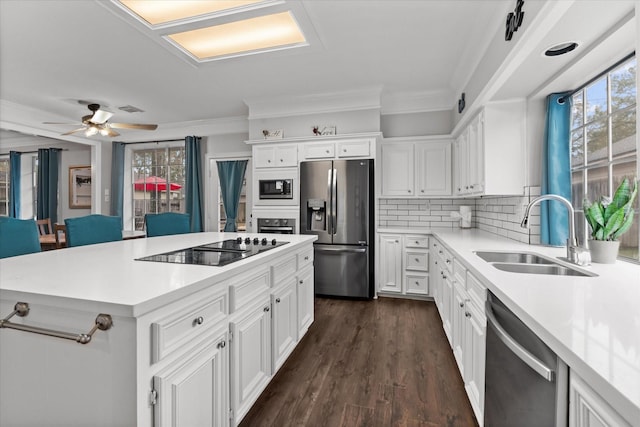 kitchen with a sink, visible vents, crown molding, a kitchen island, and appliances with stainless steel finishes