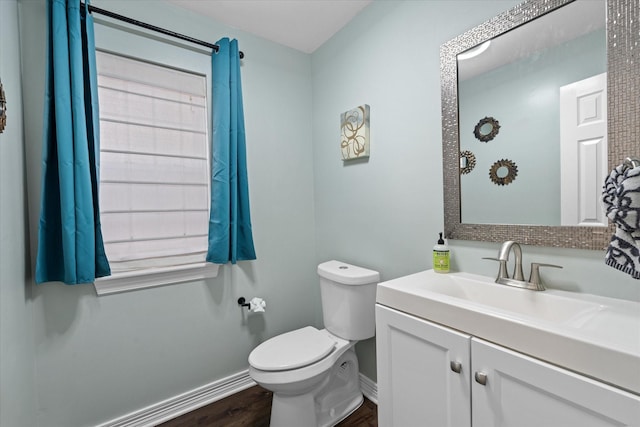 bathroom featuring vanity, toilet, baseboards, and wood finished floors