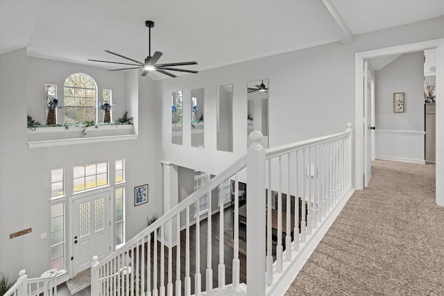 hallway with carpet floors and an upstairs landing