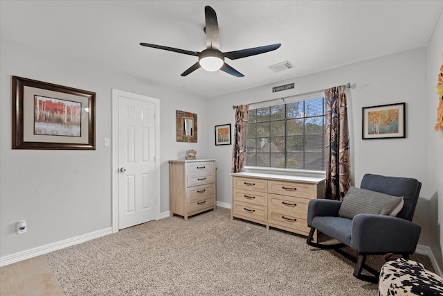 sitting room featuring light colored carpet, visible vents, baseboards, and a ceiling fan