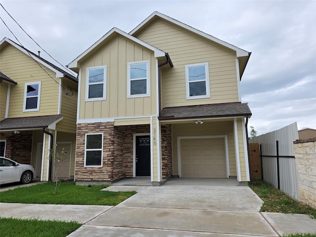 2140 De Soto St, Houston, TX 77091 - view of front of home with driveway, board and batten siding, stone siding, fence, and a garage