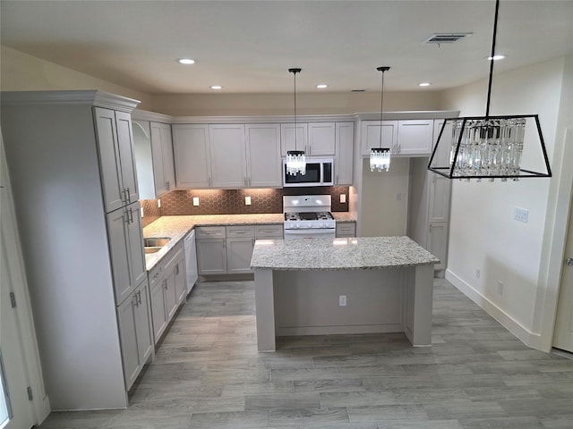 2140 De Soto St, Houston, TX 77091 - kitchen with gray cabinets, recessed lighting, white appliances, a center island, and visible vents