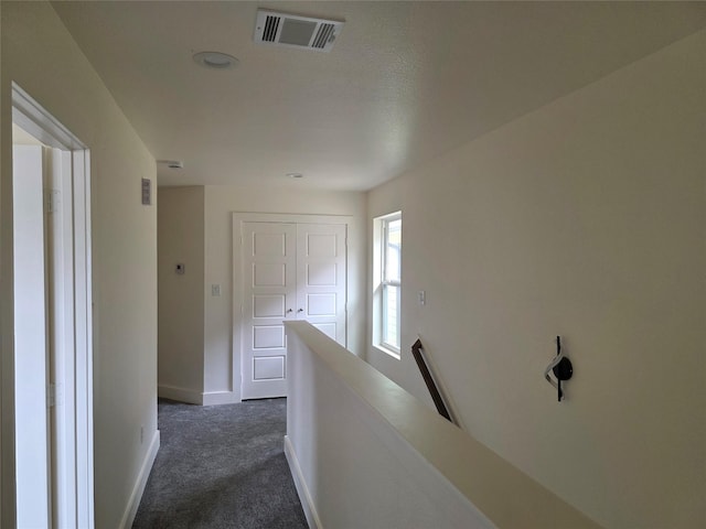 2140 De Soto St, Houston, TX 77091 - hall featuring baseboards, visible vents, dark colored carpet, and an upstairs landing