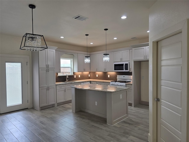 2140 De Soto St, Houston, TX 77091 - kitchen with tasteful backsplash, visible vents, stainless steel appliances, a center island, and light wood finished floors