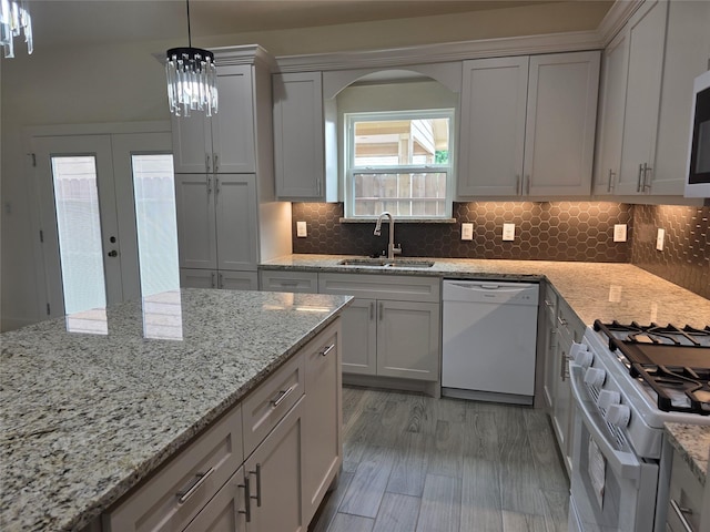 2140 De Soto St, Houston, TX 77091 - kitchen featuring light stone countertops, arched walkways, backsplash, dishwasher, and a sink