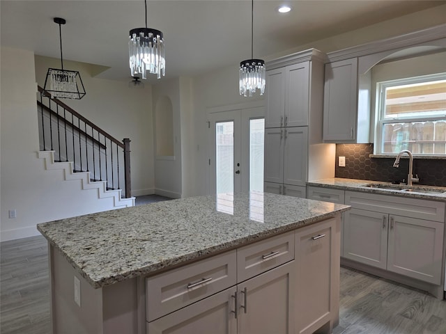 2140 De Soto St, Houston, TX 77091 - kitchen with light wood-style flooring, a sink, arched walkways, an inviting chandelier, and french doors