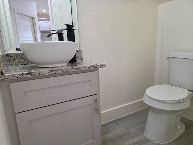 2140 De Soto St, Houston, TX 77091 - bathroom featuring toilet, wood finished floors, vanity, and baseboards