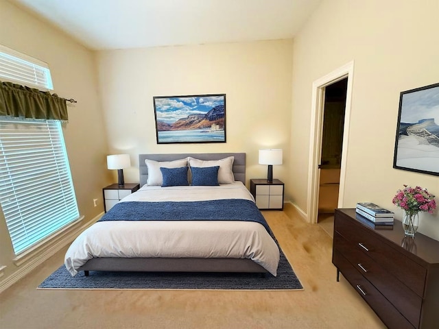 bedroom featuring baseboards and light colored carpet