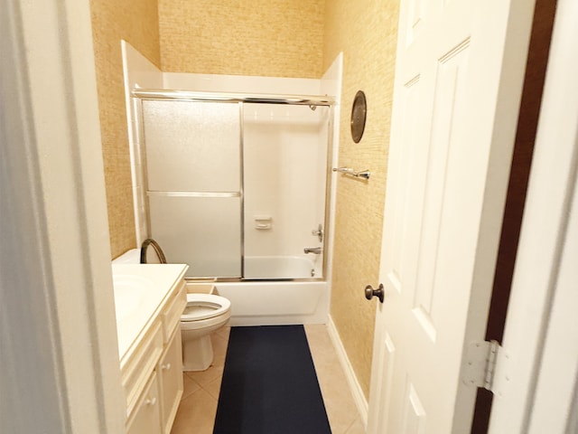 bathroom featuring tile patterned flooring, a textured wall, vanity, and toilet