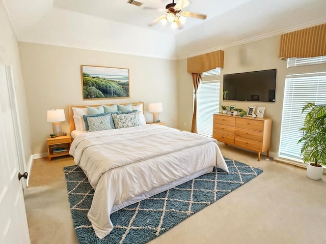 carpeted bedroom with crown molding, a raised ceiling, and ceiling fan