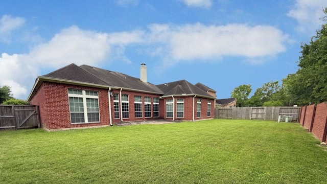 back of house with brick siding and a fenced backyard