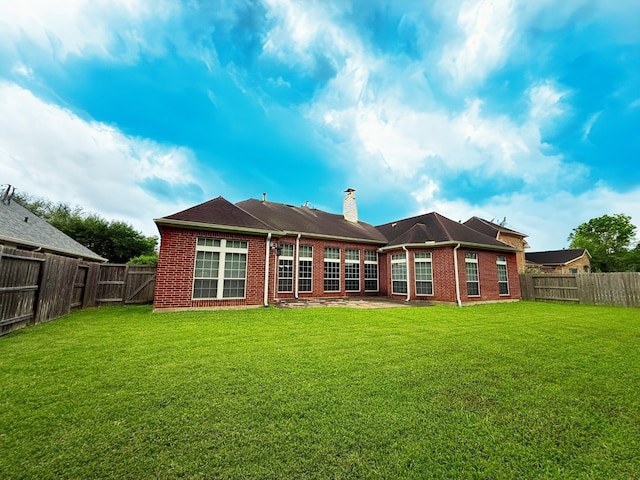 2227 Greenhaven Dr, Sugar Land, TX 77479 - rear view of property with a fenced backyard, a chimney, a yard, and brick siding
