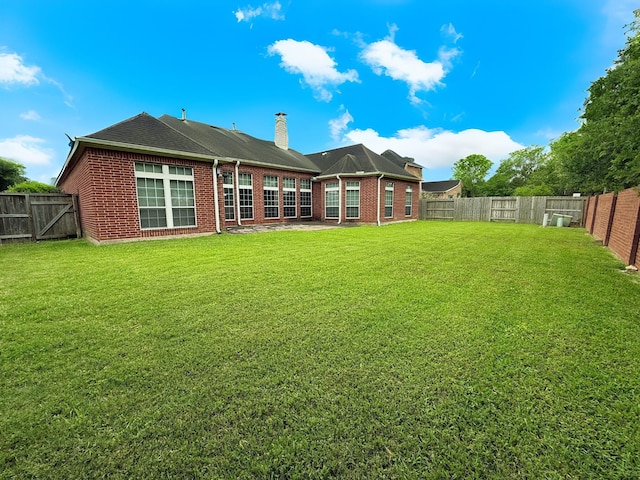 2227 Greenhaven Dr, Sugar Land, TX 77479 - back of house with a yard, a chimney, and a fenced backyard