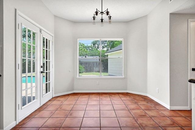 unfurnished dining area featuring baseboards, french doors, and plenty of natural light