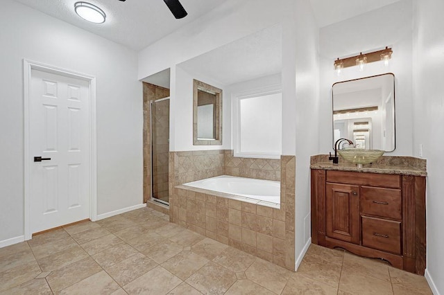 bathroom with a garden tub, vanity, a stall shower, and a ceiling fan