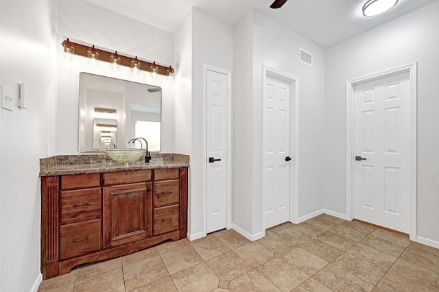 bathroom with baseboards, visible vents, and vanity