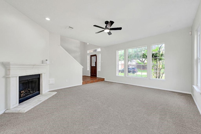 unfurnished living room featuring recessed lighting, a fireplace with raised hearth, a ceiling fan, baseboards, and carpet flooring