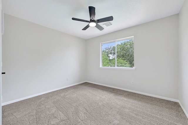 carpeted empty room featuring baseboards, visible vents, and ceiling fan