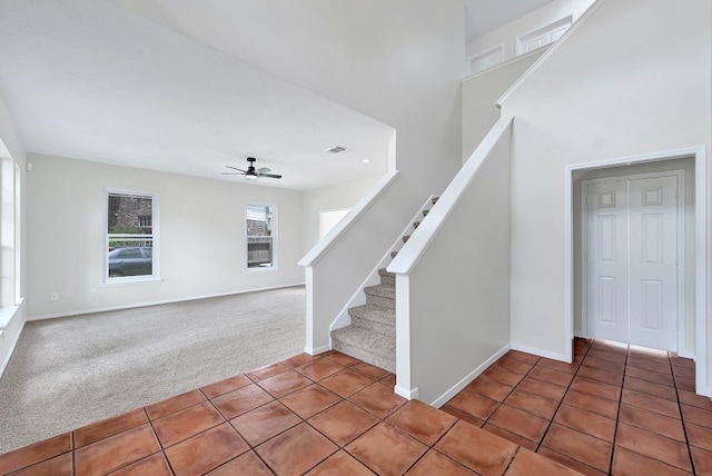 interior space featuring carpet flooring, baseboards, and tile patterned floors