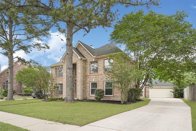 view of front of home with concrete driveway, a front lawn, brick siding, and a garage
