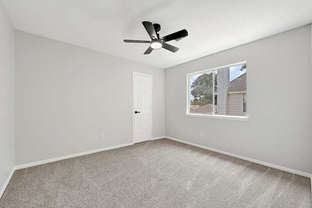 carpeted spare room with baseboards and ceiling fan