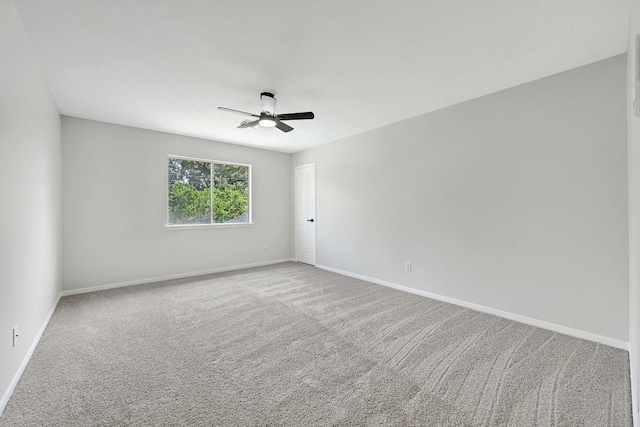spare room featuring carpet, baseboards, and ceiling fan