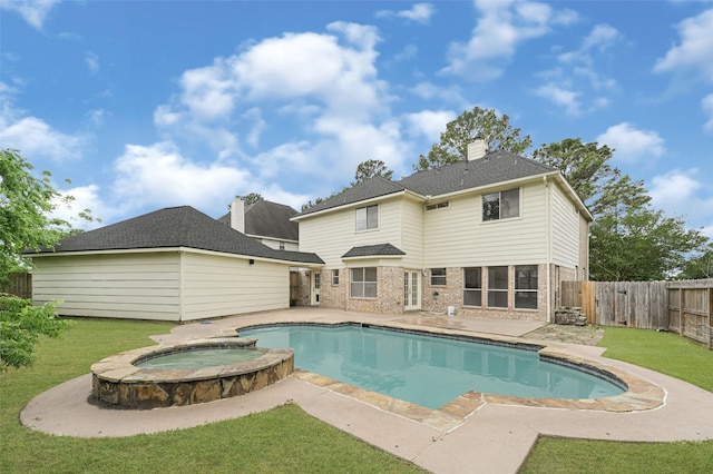 view of swimming pool featuring a yard, a pool with connected hot tub, a fenced backyard, and a patio