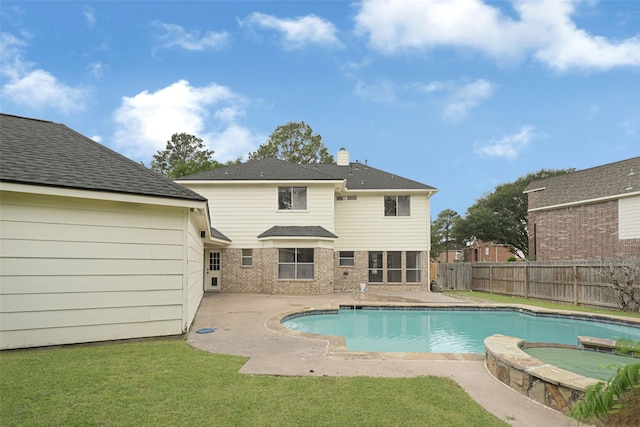 view of pool featuring a fenced backyard, a yard, a pool with connected hot tub, and a patio