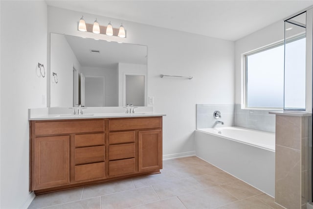bathroom with a bath, a sink, double vanity, visible vents, and tile patterned flooring