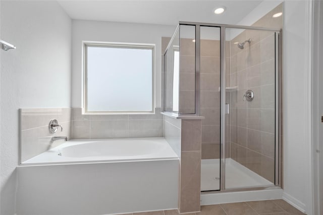 bathroom with recessed lighting, a bath, tile patterned flooring, and a stall shower