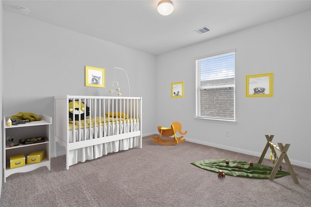 carpeted bedroom with baseboards, visible vents, and a nursery area