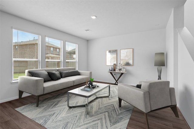 living area with baseboards, wood finished floors, visible vents, and recessed lighting