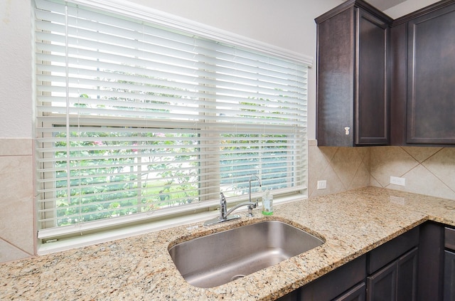 24430 Vittorio Wood Ln, Katy, TX 77493 - kitchen with a sink, dark brown cabinets, light stone countertops, and decorative backsplash