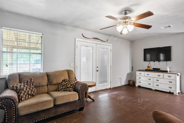 living area with visible vents, a ceiling fan, and french doors