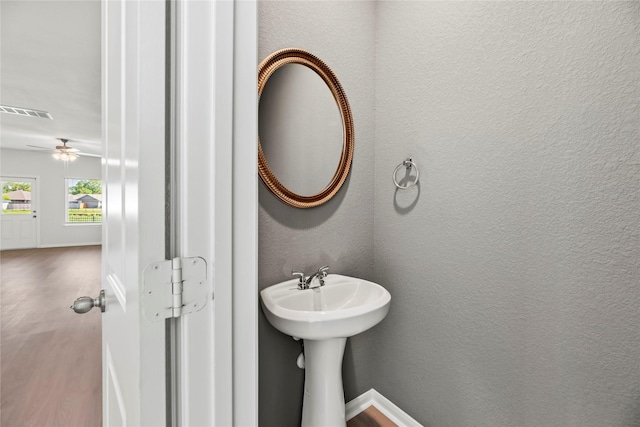 bathroom featuring a sink, visible vents, wood finished floors, ceiling fan, and a textured wall