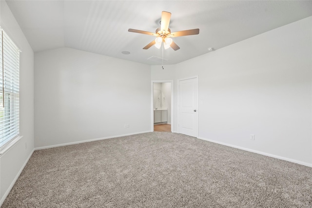 carpeted spare room with vaulted ceiling, baseboards, and ceiling fan
