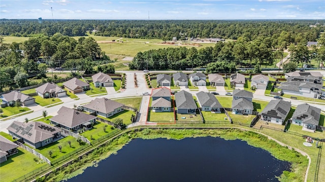 aerial view with a wooded view, a residential view, and a water view